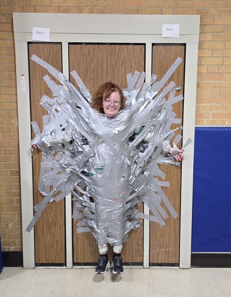 Mrs. Tierney taped to a wall while smiling