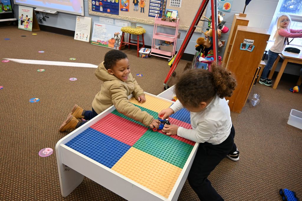 Two students play with Lego Police cars.