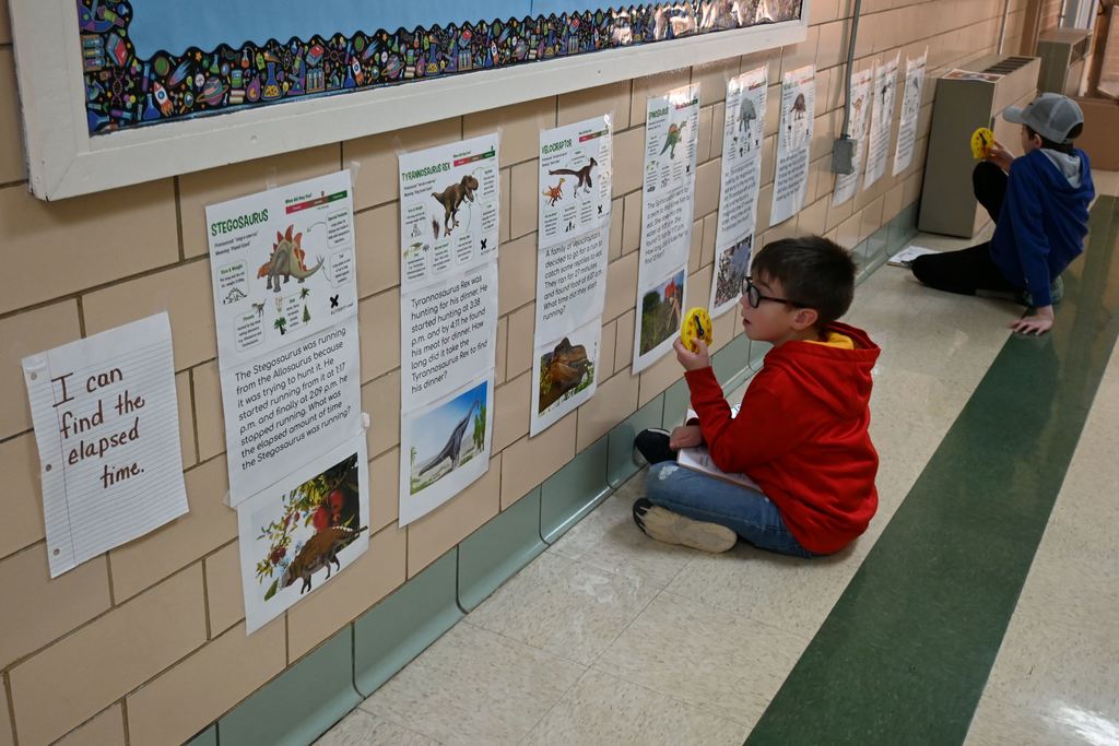 Two students work to  find the elapsed amount of time between various dinosaurs existence.