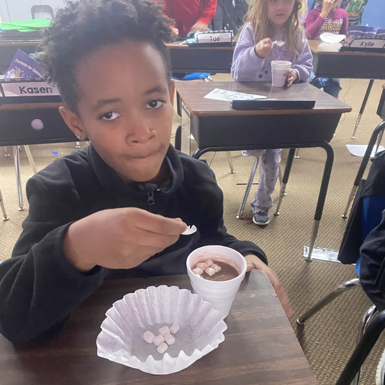 student drinking hot chocolate at their desk