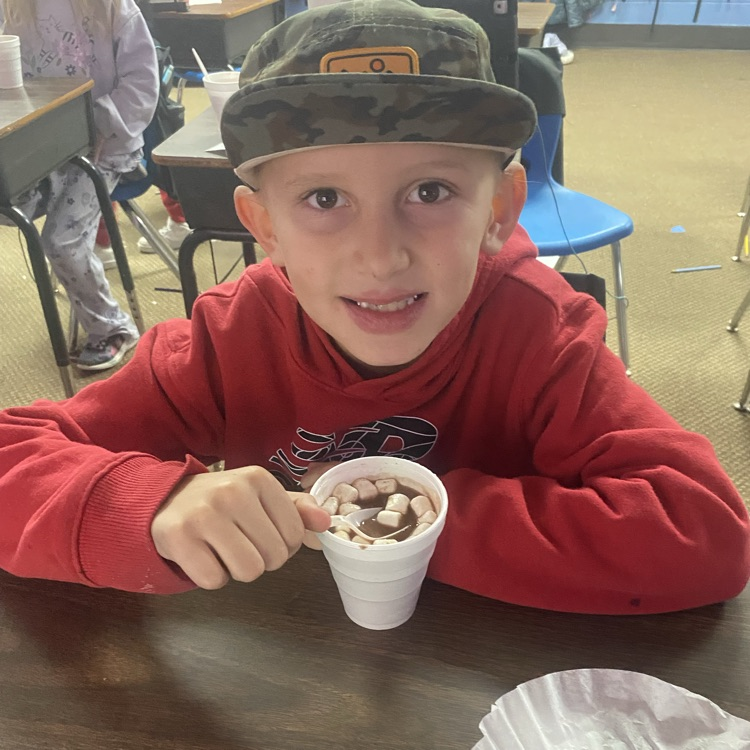 student drinking hot chocolate at their desk