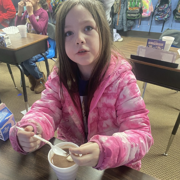 student drinking hot chocolate at their desk