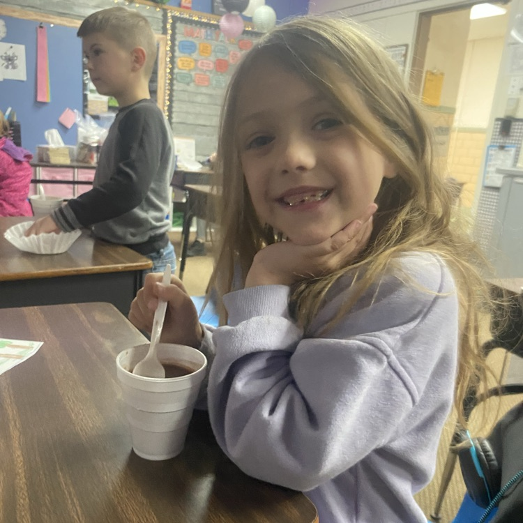 student drinking hot chocolate at their desk