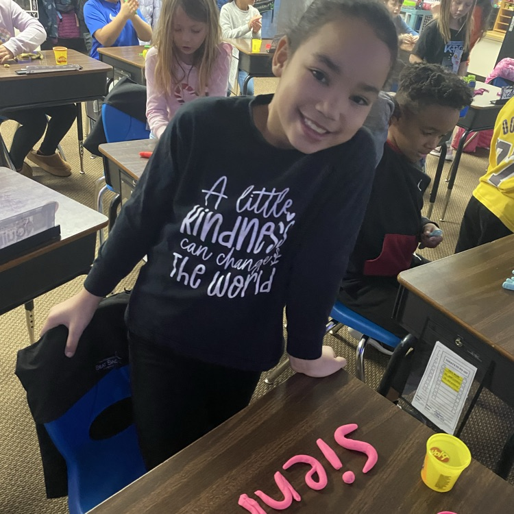 student using Play-Doh to fill out their name