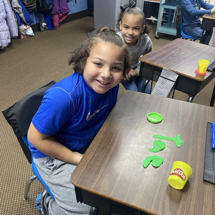 student using Play-Doh to fill out their name