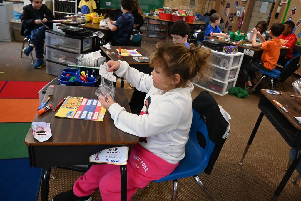 A student removed items from a baggie she will glue into a flip book.