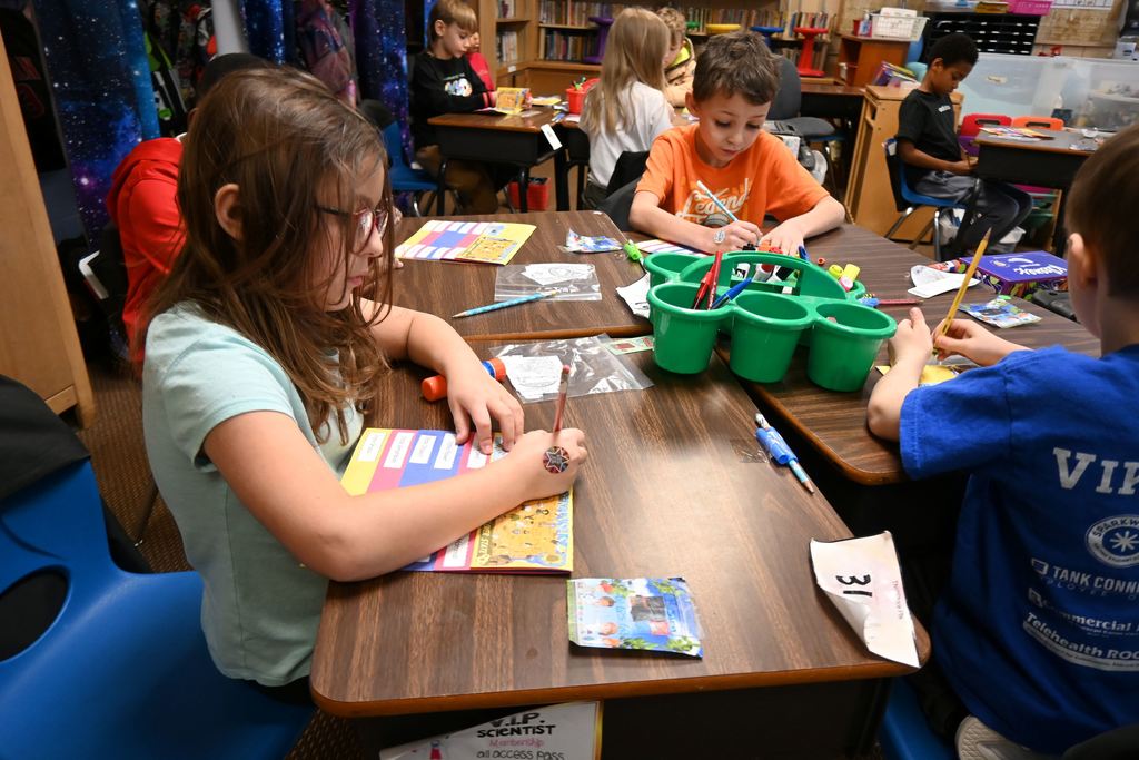 Students glue pictures and descriptions into flip books.
