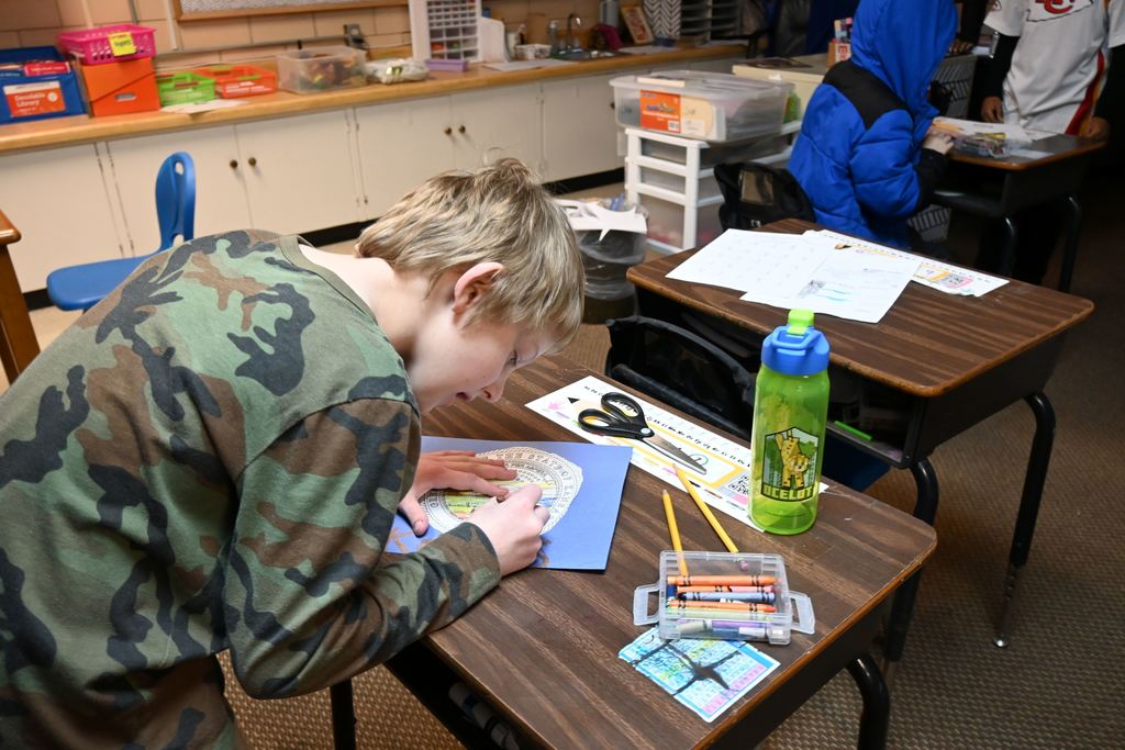 A student colors the Kansas Seal on a state flag they are making.