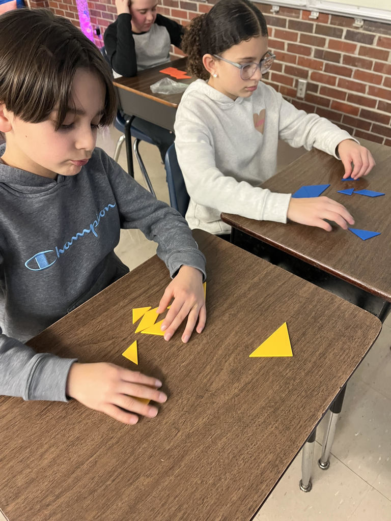 Students solve tangram puzzle.