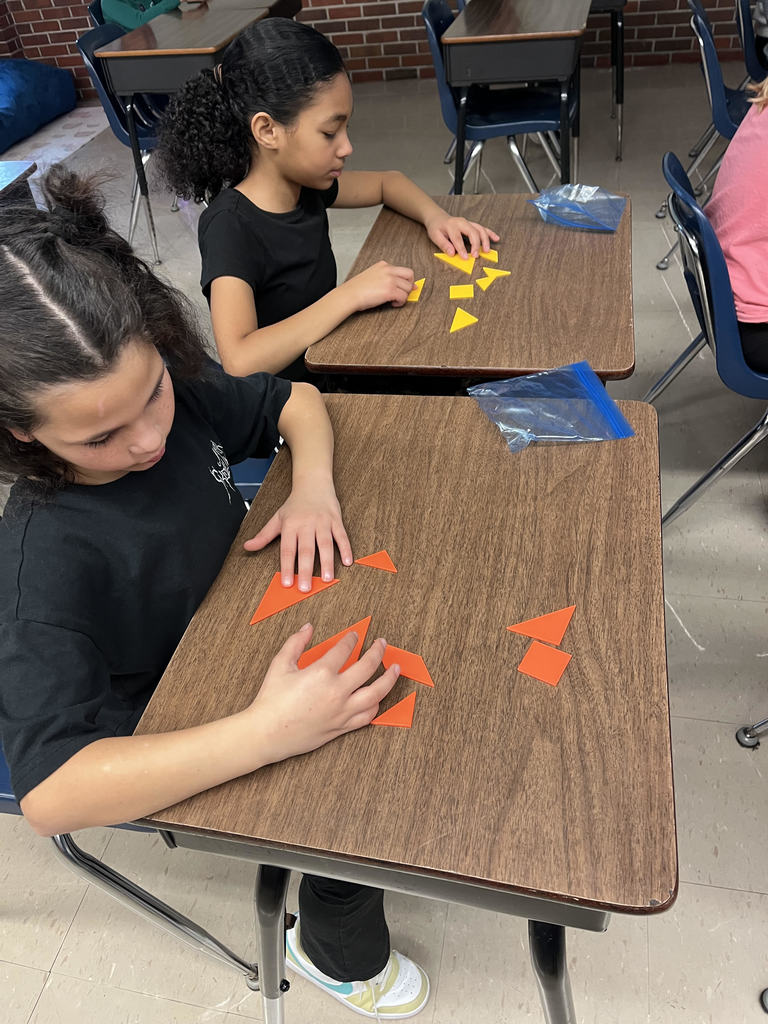 Students solve tangram puzzle.