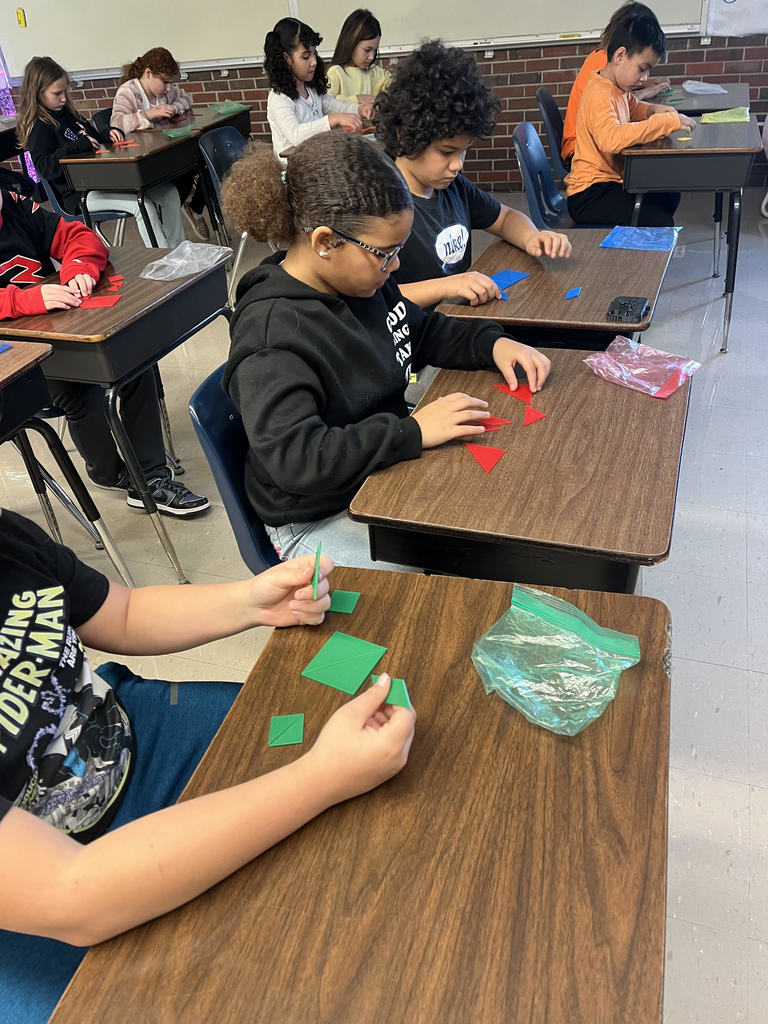 Students solve tangram puzzle.