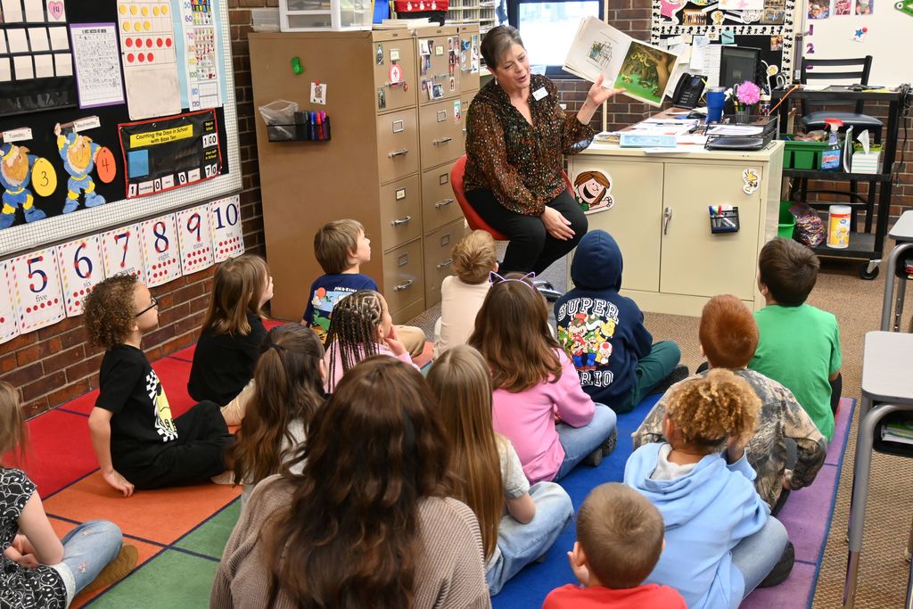 Lori Perkins reads to first grade students.