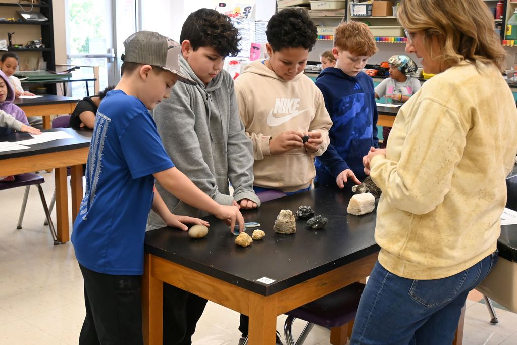 Students check out the wide variety of rocks, Mrs. Piva brought, including a Geode with crystals inside.