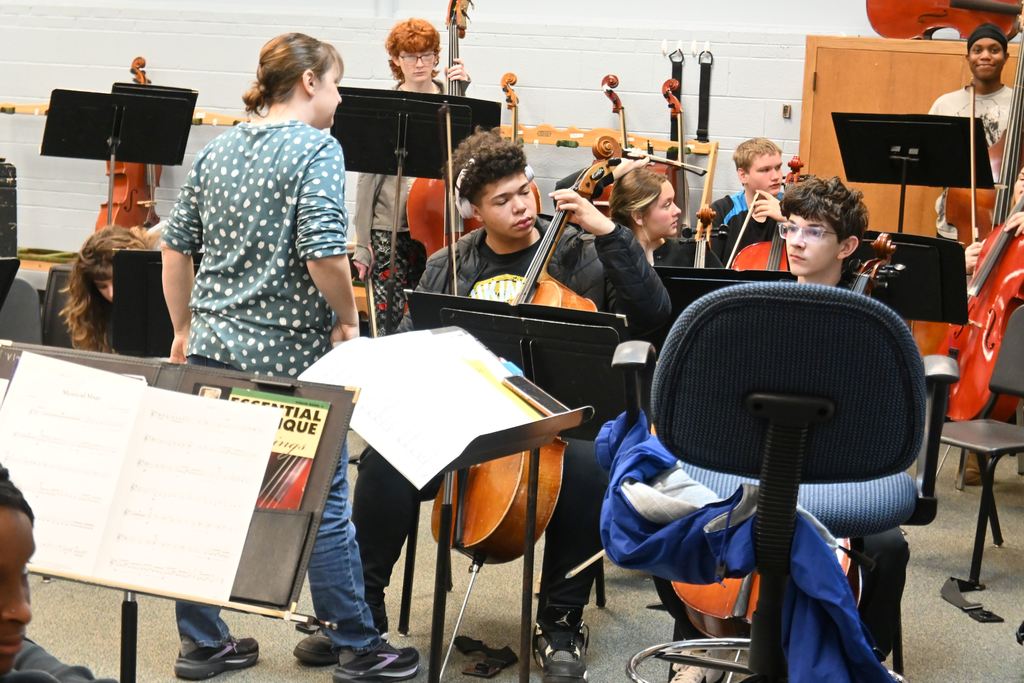 Mrs, Oberle helps a student tune his cello.