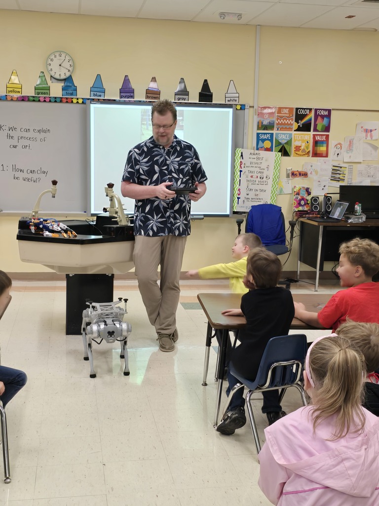 Mr. Peak shows first grade students the district's quadruped Vector.