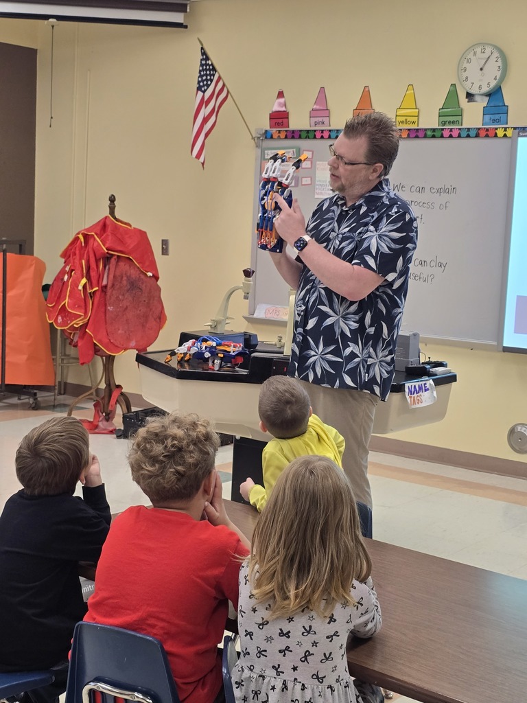 Mr. Peak shows students the teaching pneumatic robot hand.
