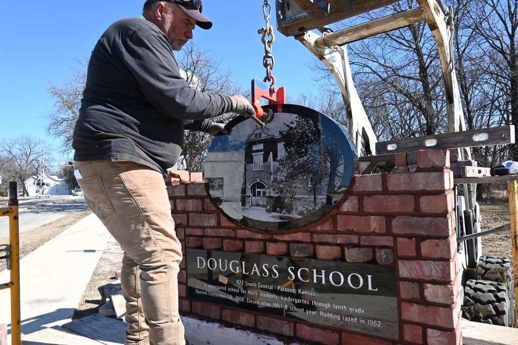 Doug Strong makes last minute adjustments to the angle of the oval stone before seating it in its bed of mortar.