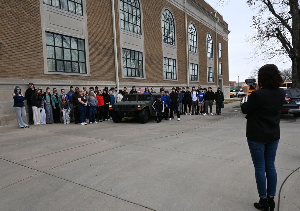 Parsons High School students stand outside with the Humvee donated by USD 503 tohelp pay for the memorial.