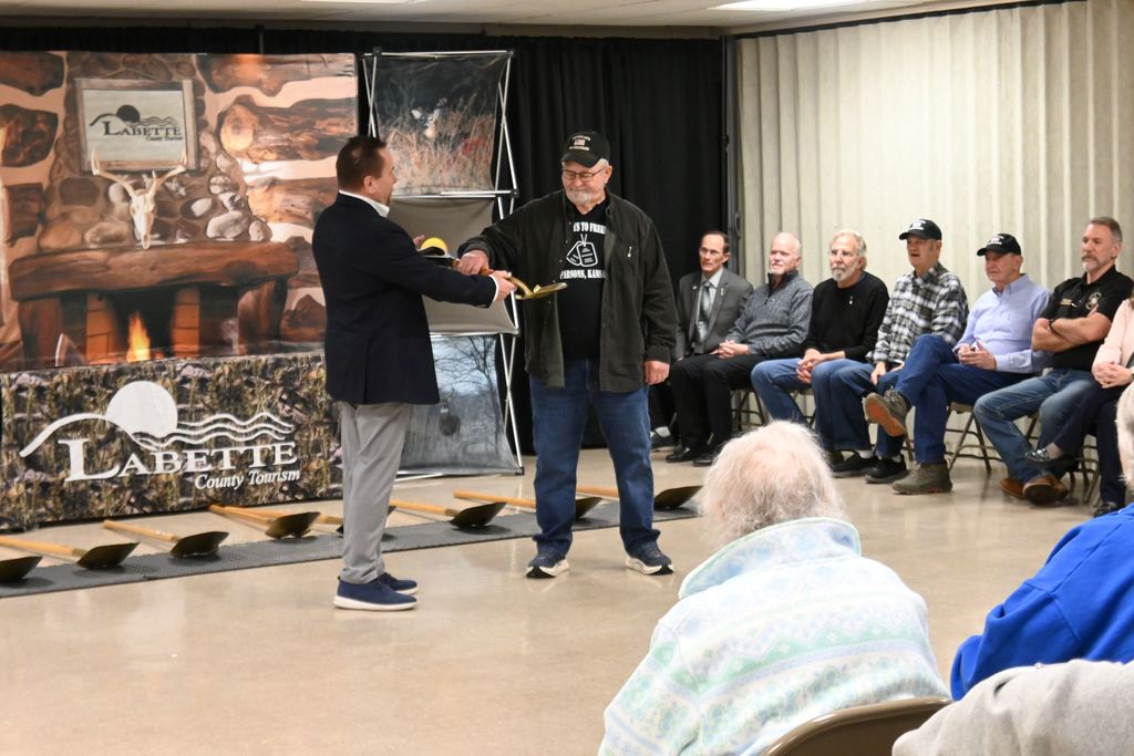 Carl Hoskins receives a signed shovel for his efforts in leading the way to getting the memorial.