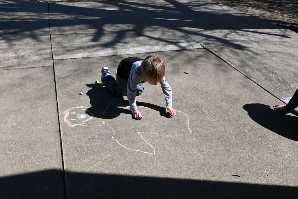 A student draws details into his shadow outline.