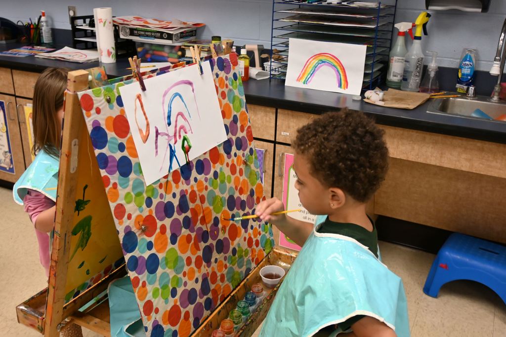 A student paints a rainbow.