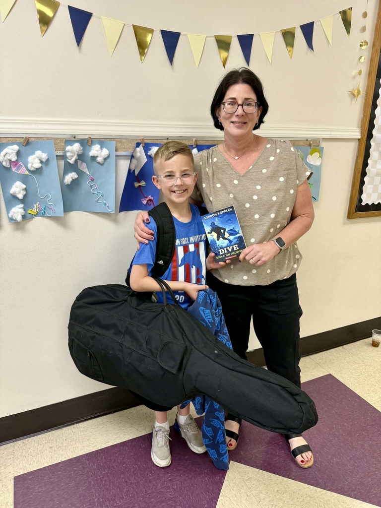 Mrs. Armstrong being gifted a book for her classroom.