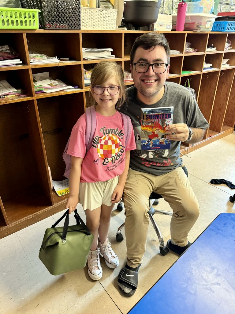 Mr. Holmes being gifted a book for his classroom.