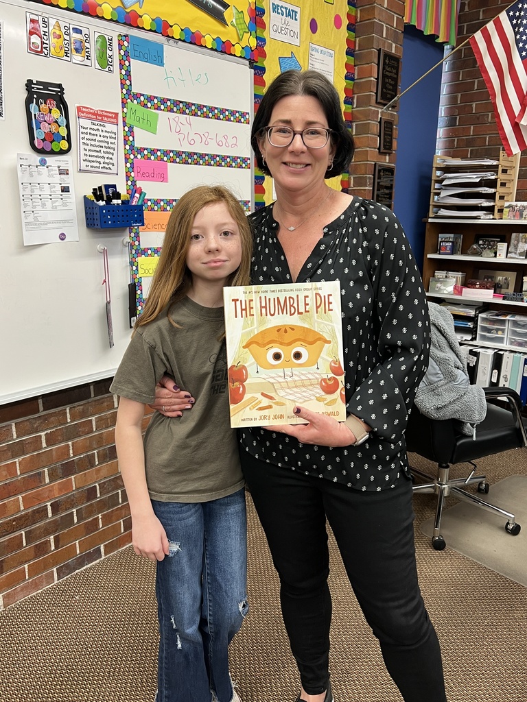 Mrs. Armstrong being gifted a book for her classroom.