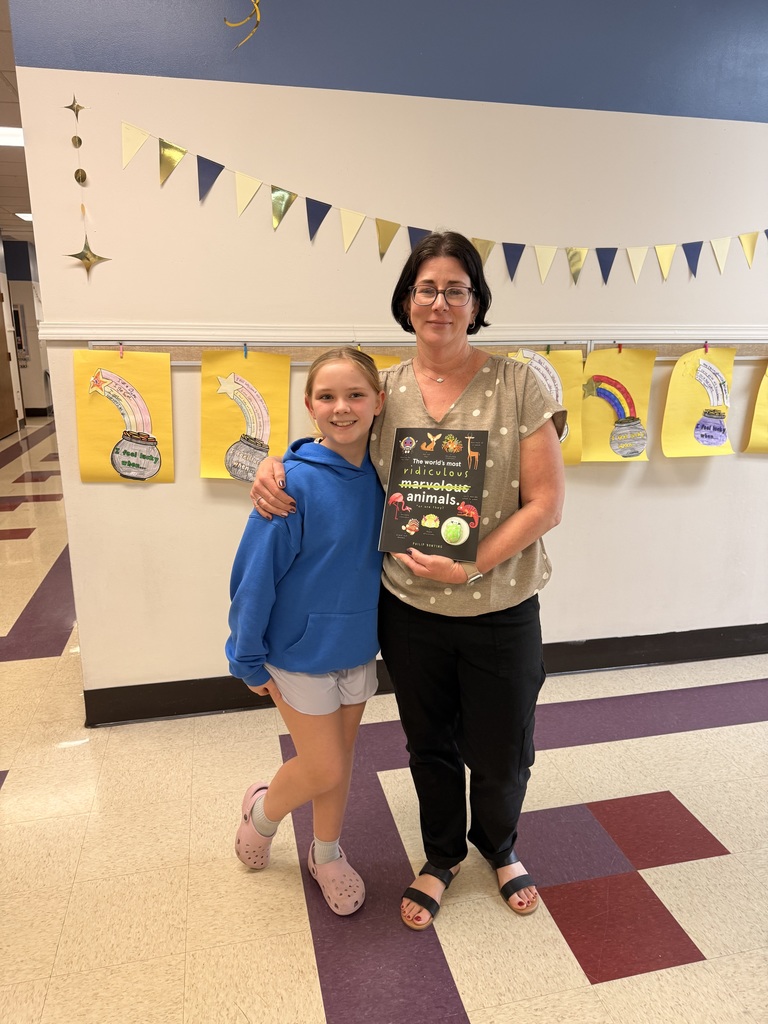 Mrs. Armstrong being gifted a book for her classroom.
