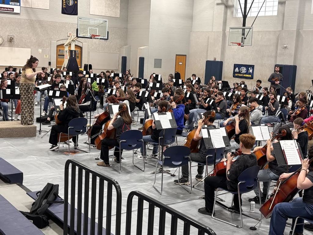 An instructor conducts the mass orchestra.
