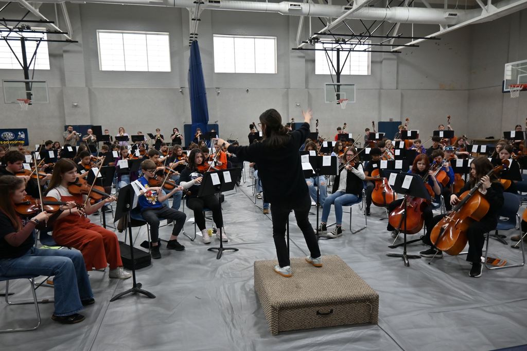 A teacher conducts the mass orchestra.