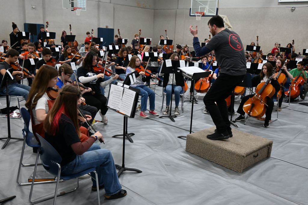 An instructor directs the mass orchestra.