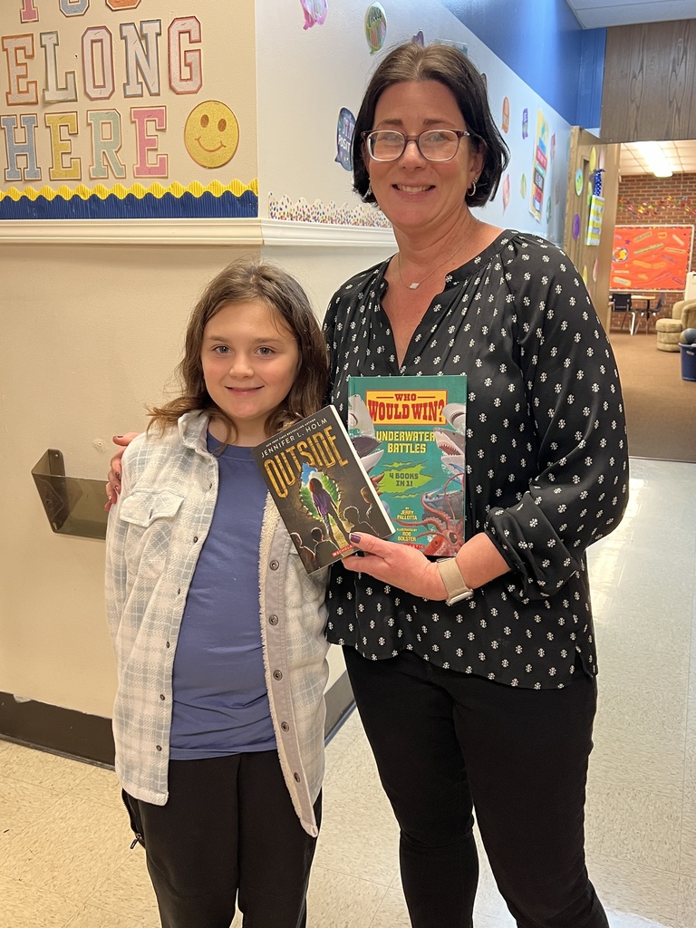 Mrs. Armstrong being gifted books for her classroom.