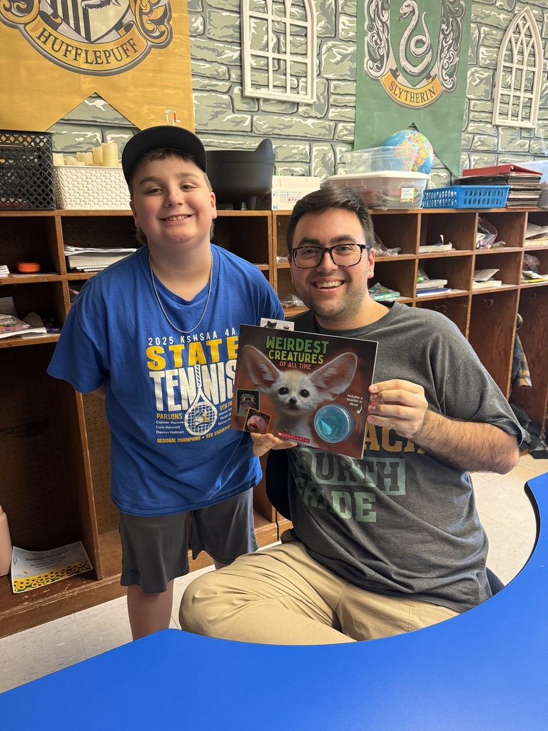 Mr. Holmes  being gifted a book for his classroom.