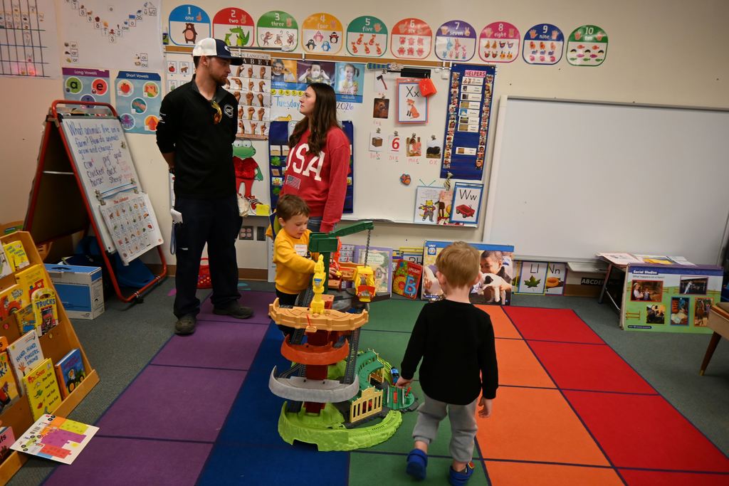Children play with toys in a preschool classroom.