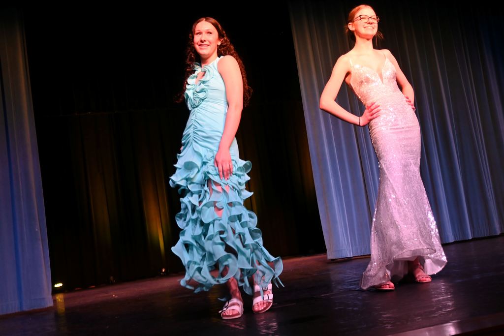 Two girls model prom dresses.