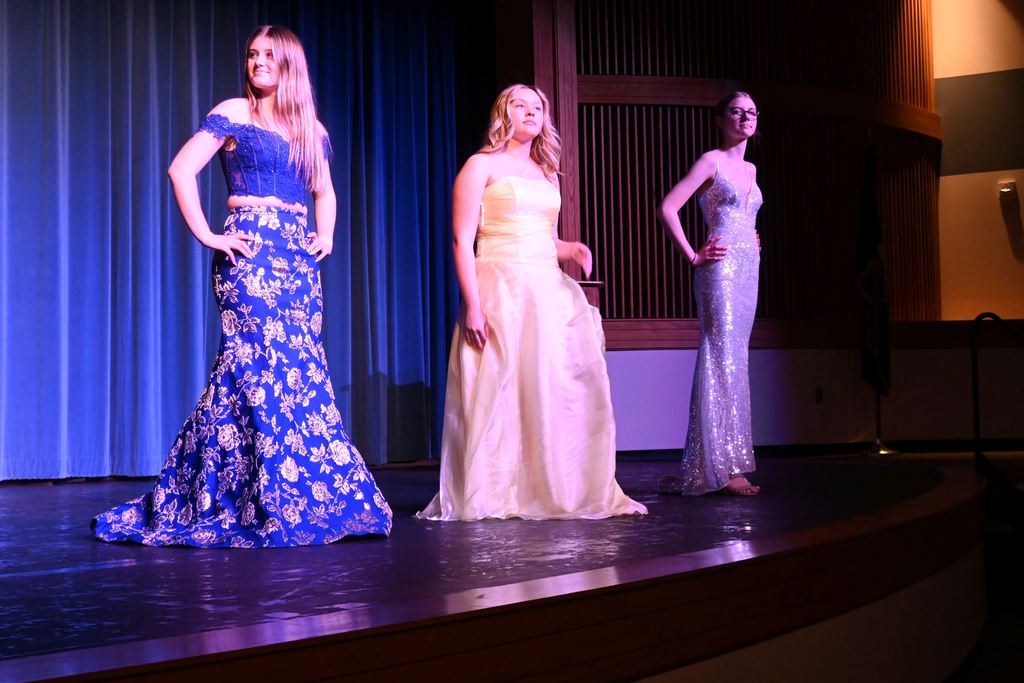 Three girls model prom dresses.