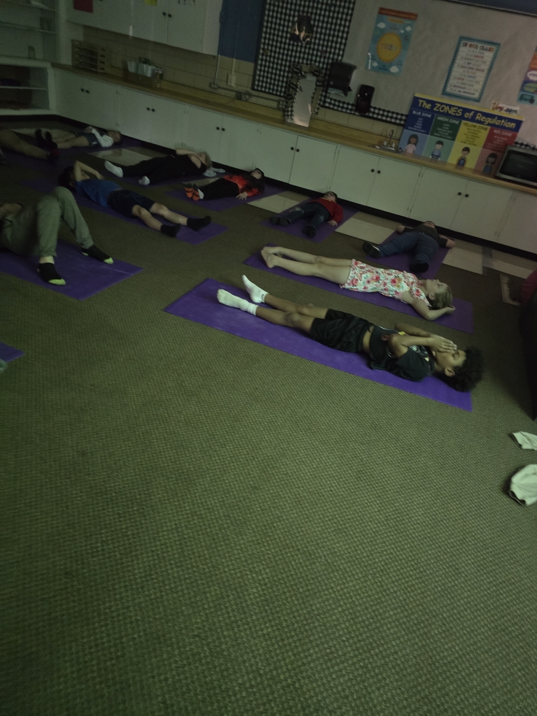 children laying on yoga mats relaxing
