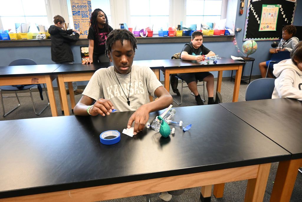 Astudent makes last minute adjustements to his car.