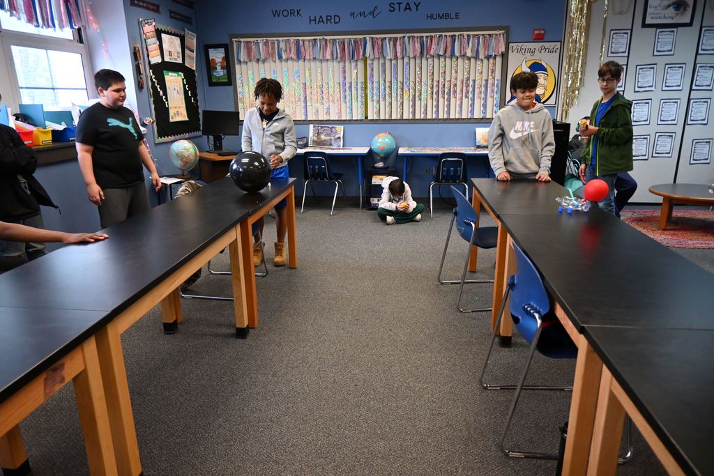 Two students race their balloon cars.