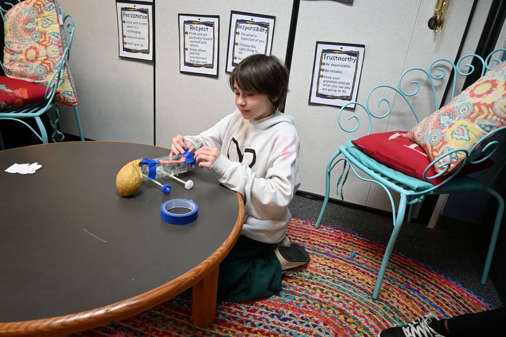 A student makes last minute adjustements to his car.