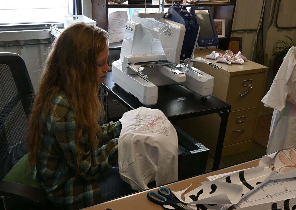Mrs.Telfer shows the results from the embroidy machine she is getting going for this coming school year.