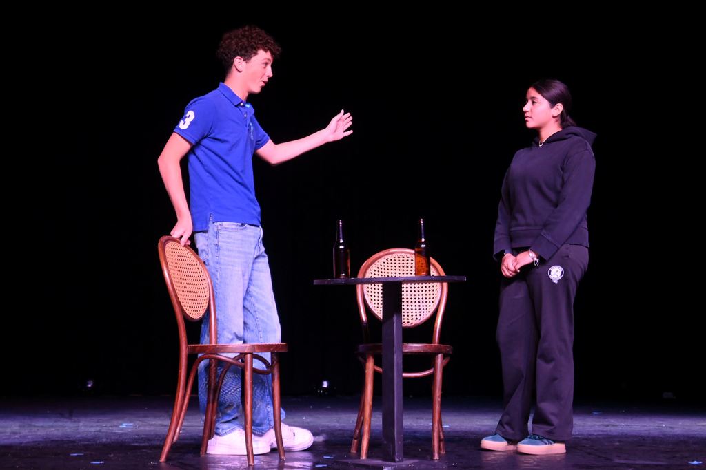 A man and a woman talk at a restaurant.