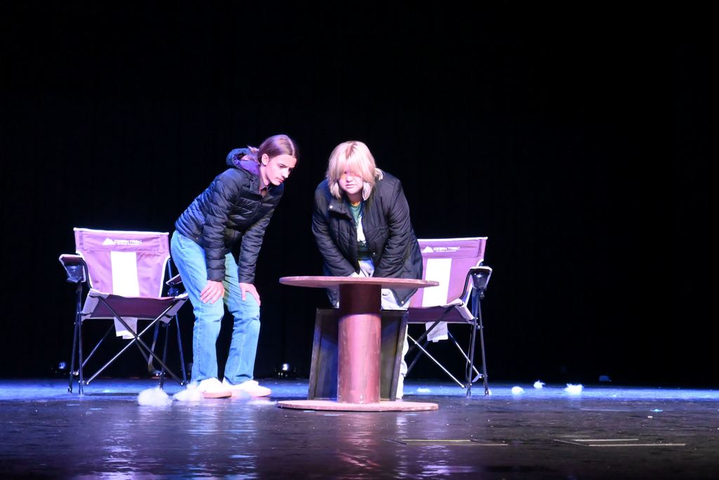 A man and a woman talk about a painting.