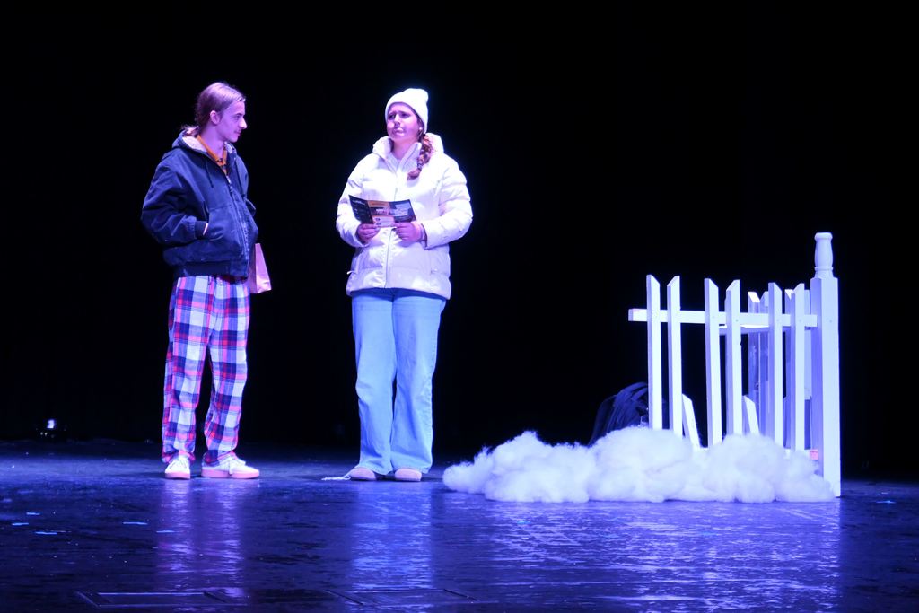 A man and a woman stand in a backyard talking.