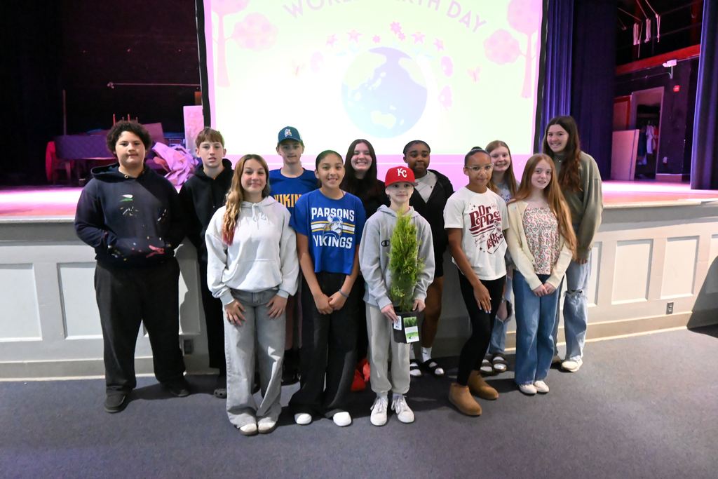 The Parsons Middle School Leadership Class stands with a tree they are going to plant.