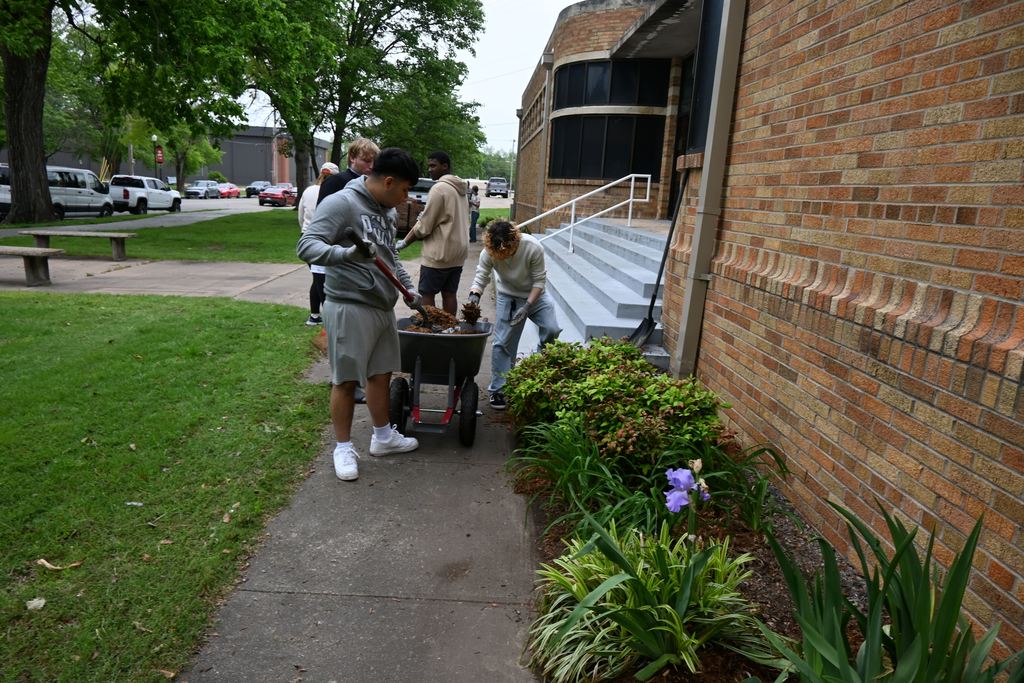 Students mulch a garden bed.