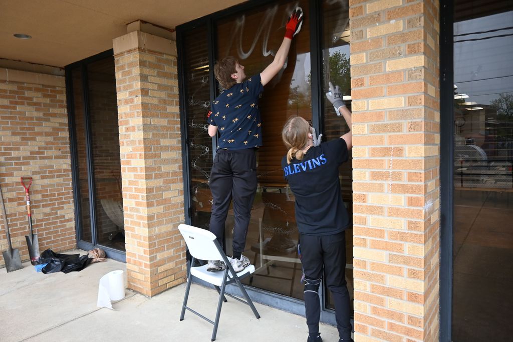 Atudents clean windows at the rec center.