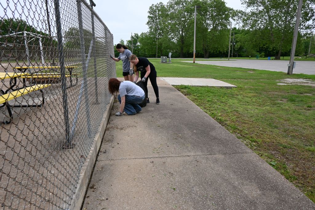Students weed along the perimeter of the pool.