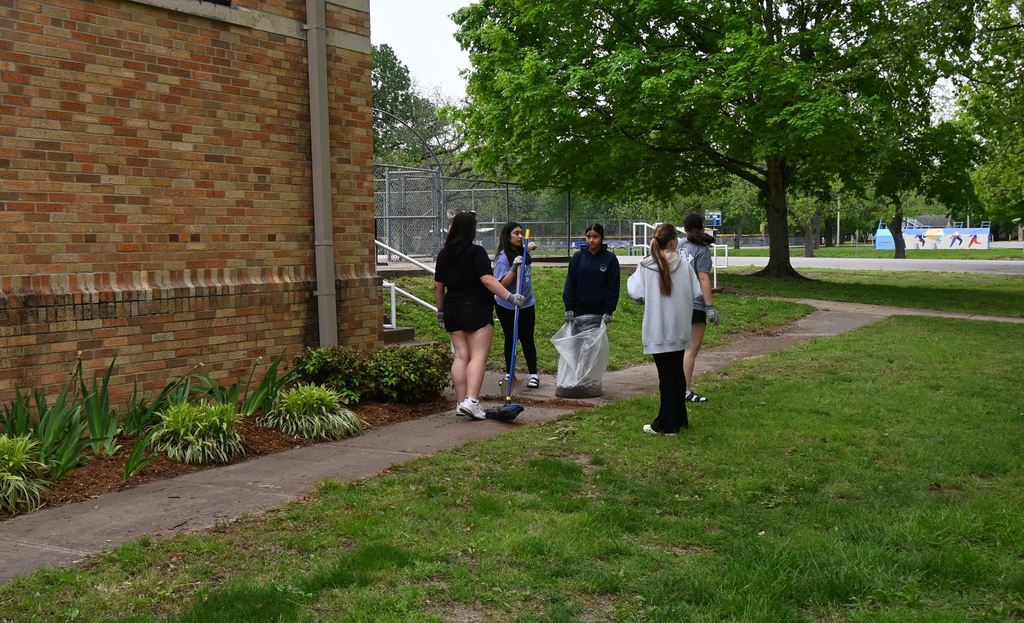 Students sweep the side walks after mulching was completed.